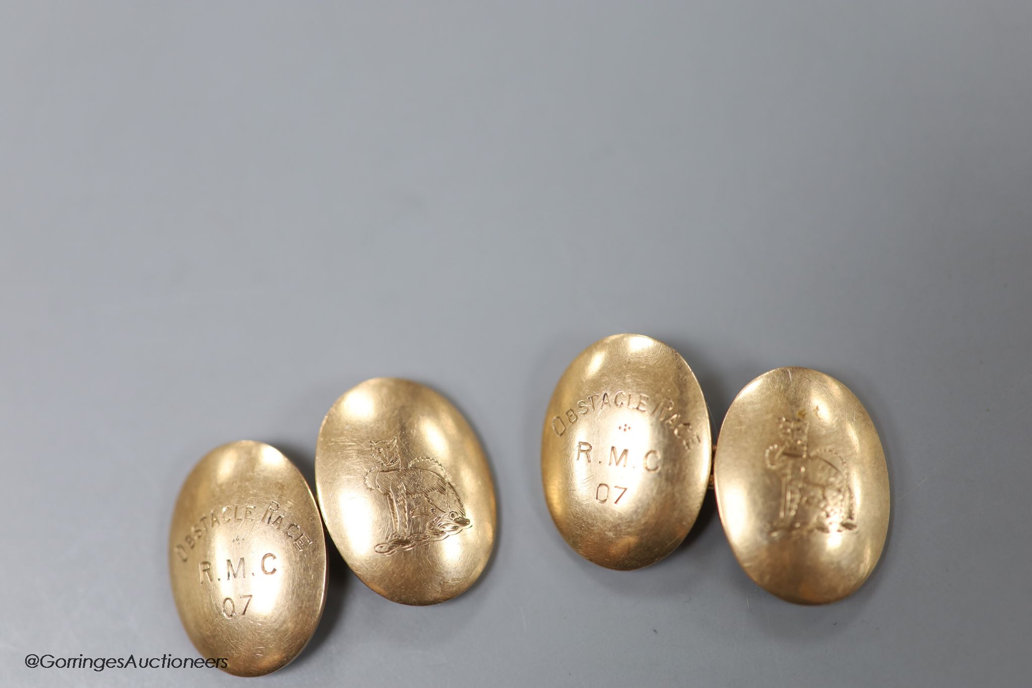 A pair of early 20th century 9ct gold oval cufflinks, engraved with crest and date